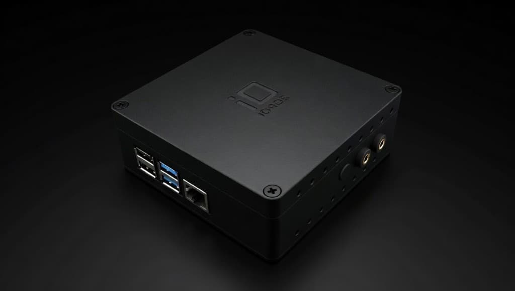 Matte black edge gateway enclosure with USB and Ethernet ports, sensor jacks, and side ventilation, on a dark studio background